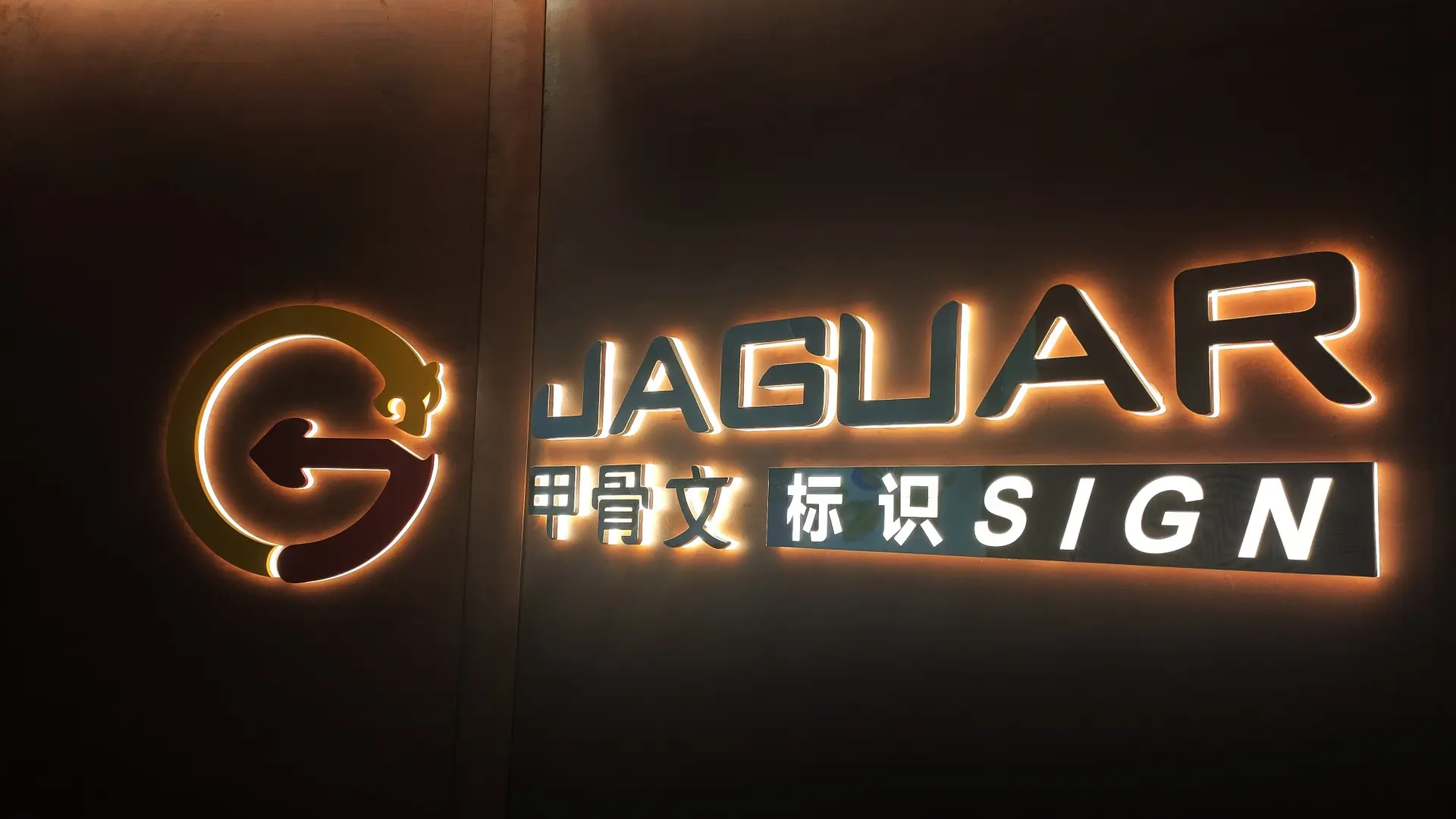 Le logo et le lettrage rétroéclairés de Jaguar Sign sur le mur des bureaux de l’entreprise
