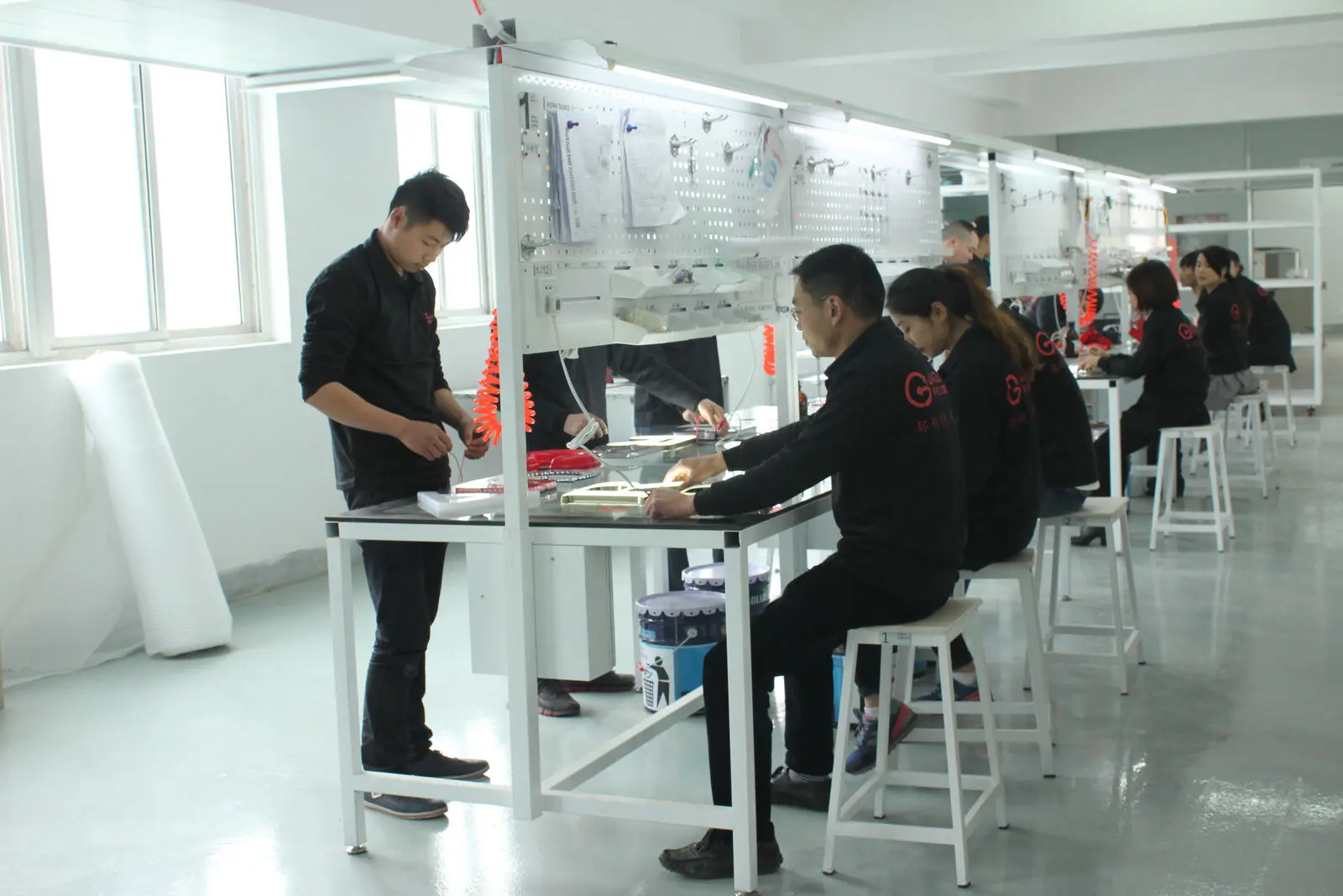 Des employés de Jaguar Sign câblent et assemblent des lettres lumineuses à l’usine de Chengdu