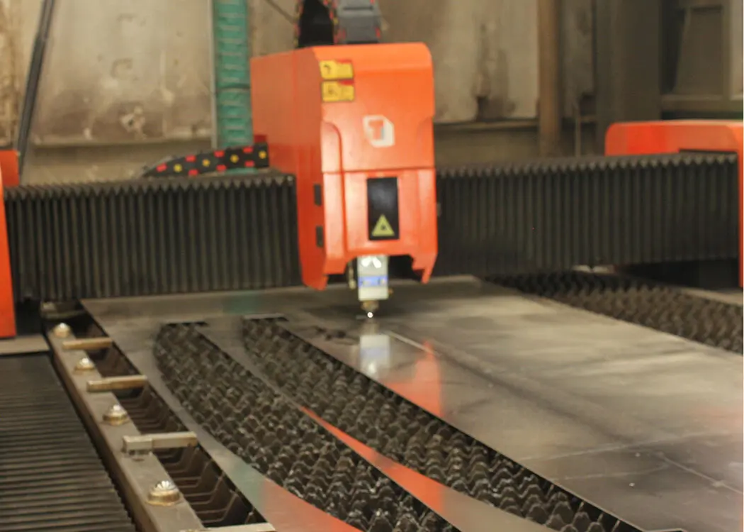 Large-scale laser cutting a metal sheet