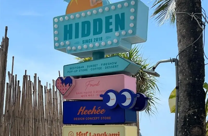 Mastschild von Hof Langkawi mit geformten Mietertafeln am Strand