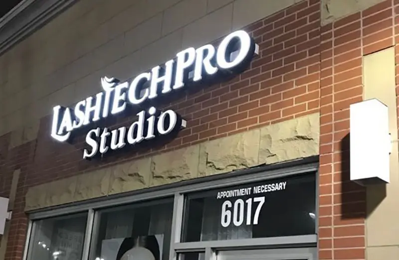 Frontleuchtende Profilbuchstaben von LashTechPro Studio an einer Backstein-Ladenfront bei Nacht