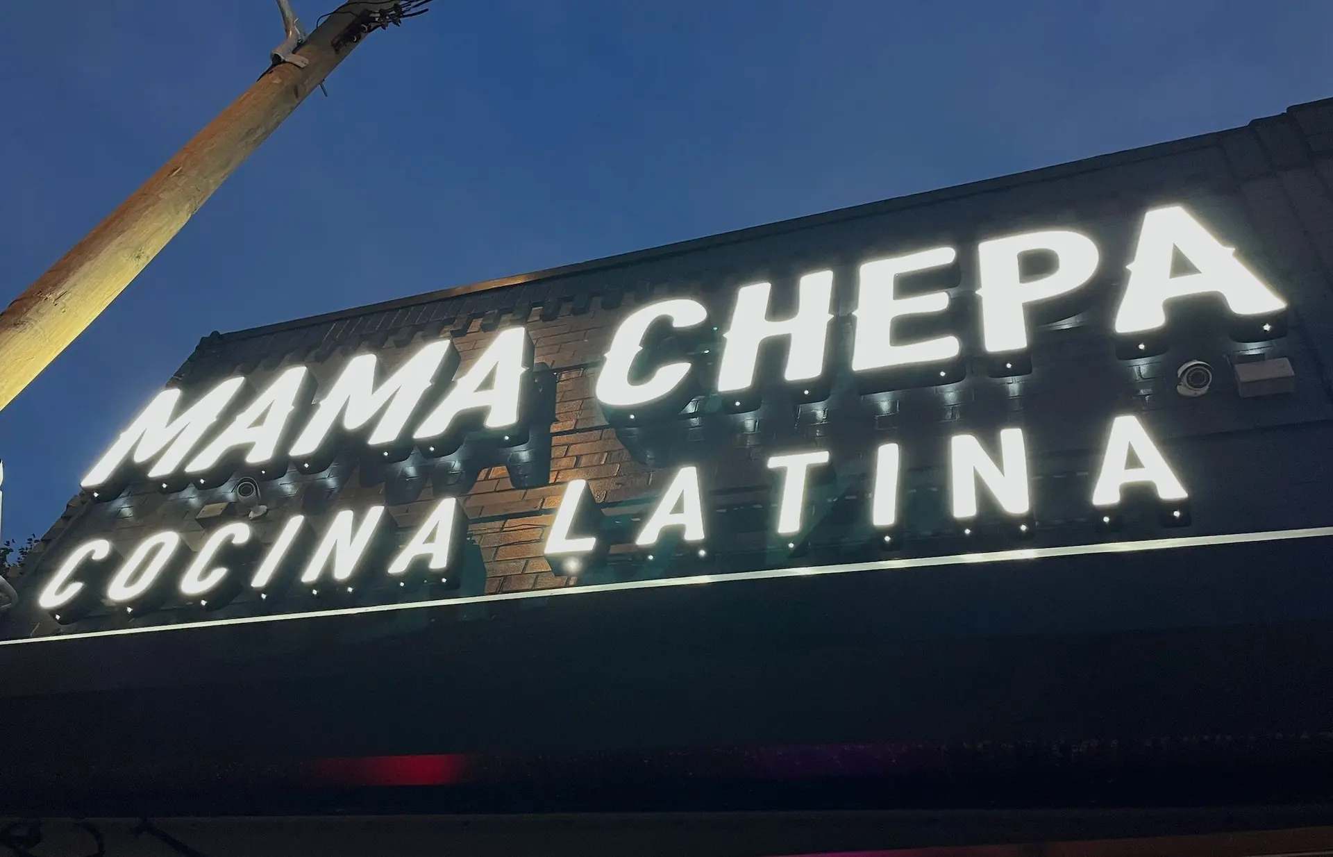 Letras corpóreas de Mama Chepa Cocina Latina instaladas en la fachada de noche