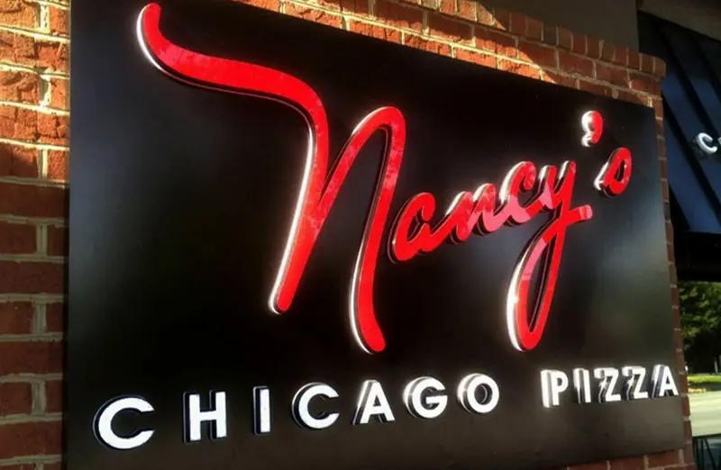 Beleuchtete Acrylbuchstaben von Nancy's Chicago Pizza auf einer schwarzen Tafel